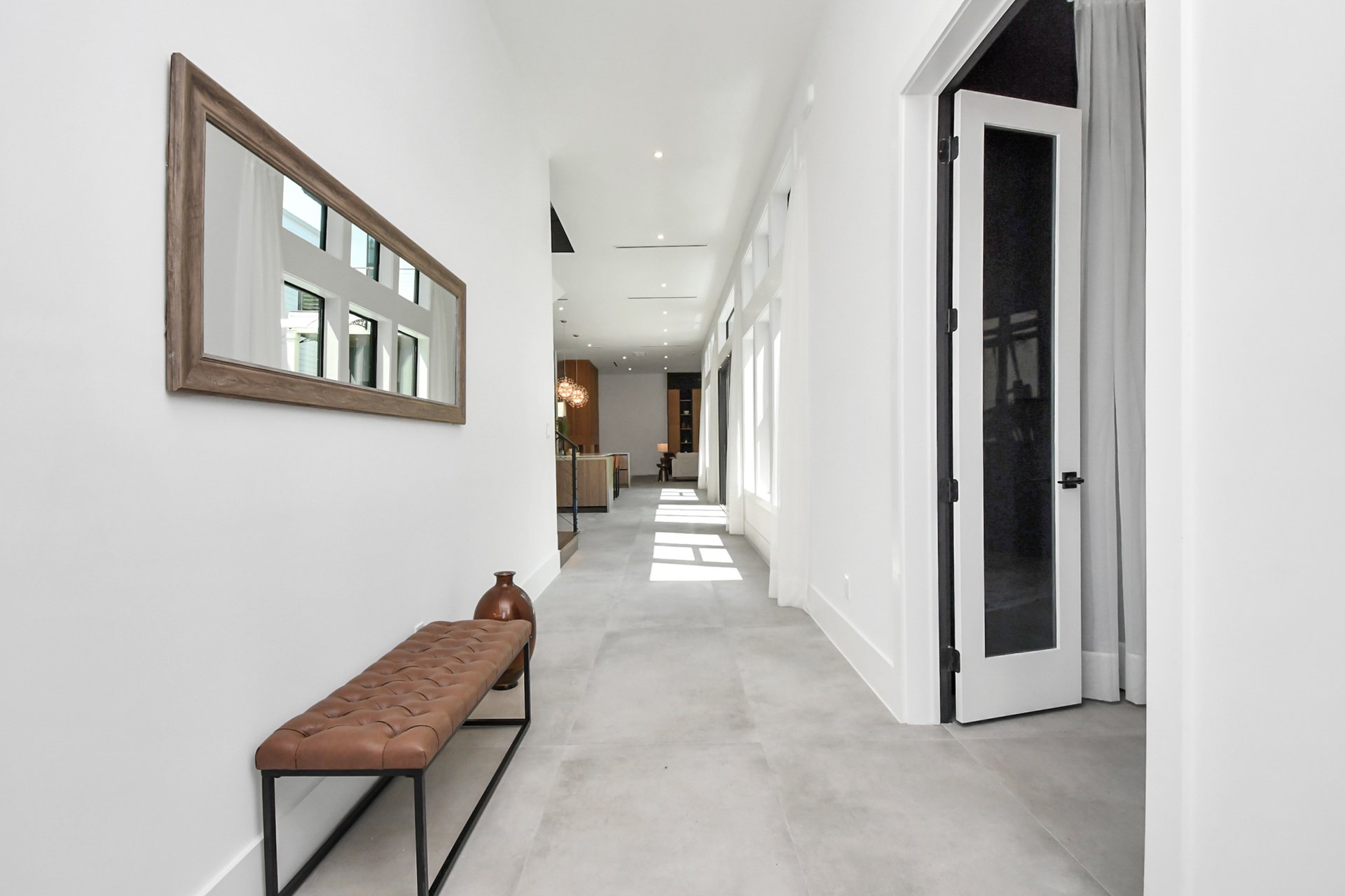 Entrance hallway with a leather bench and morning light