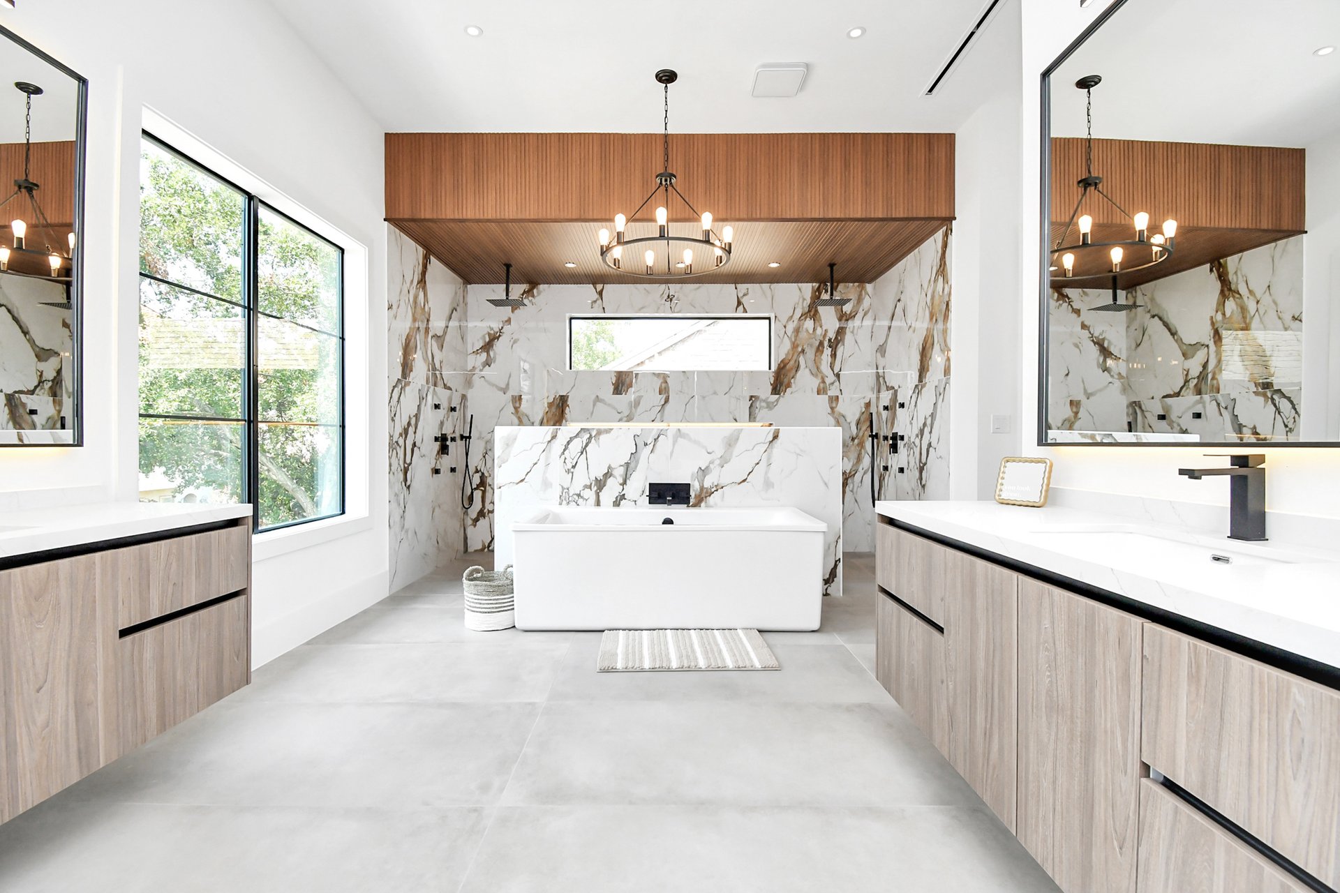 Main suite bath with calacatta marble walls and a freestanding tub